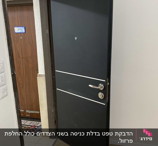 דלת שחורה עם ידית כסופה ופסים לבנים